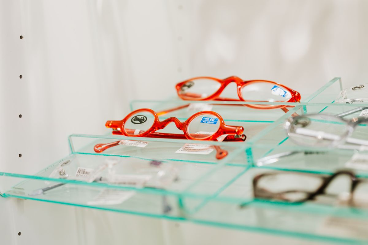 Black-framed eyeglasses resting on the keyboard of an open laptop