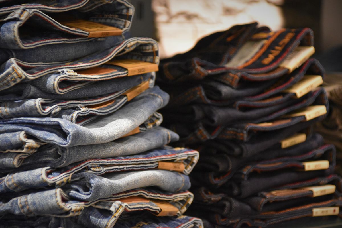 Stacked pile of blue denim jeans folded by the waistband