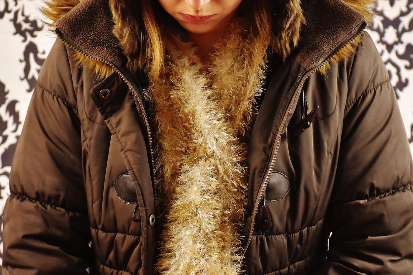Natural brown fur trim on the hood of a winter parka laid on a neutral background