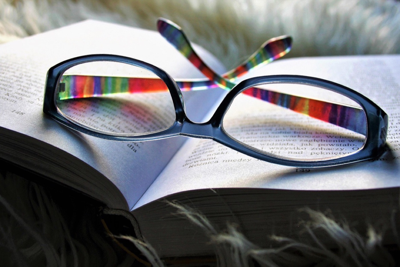 Eyeglass lens tilted under light showing the green residual reflection of an AR coating stack