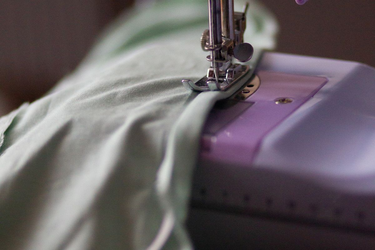 Inside of a garment showing overlocked and double-stitched seam lines on folded fabric