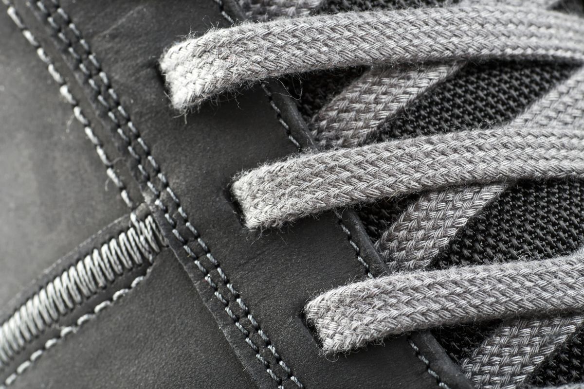 Close-up of a sneaker's laced eyestay showing padded tongue and threaded eyelets