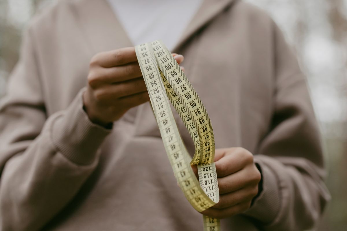 Measuring tape laid next to a pair of leather shoes