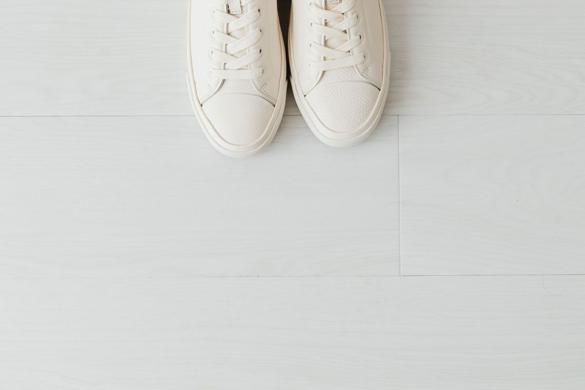 Pair of white leather sneakers on a plain studio background