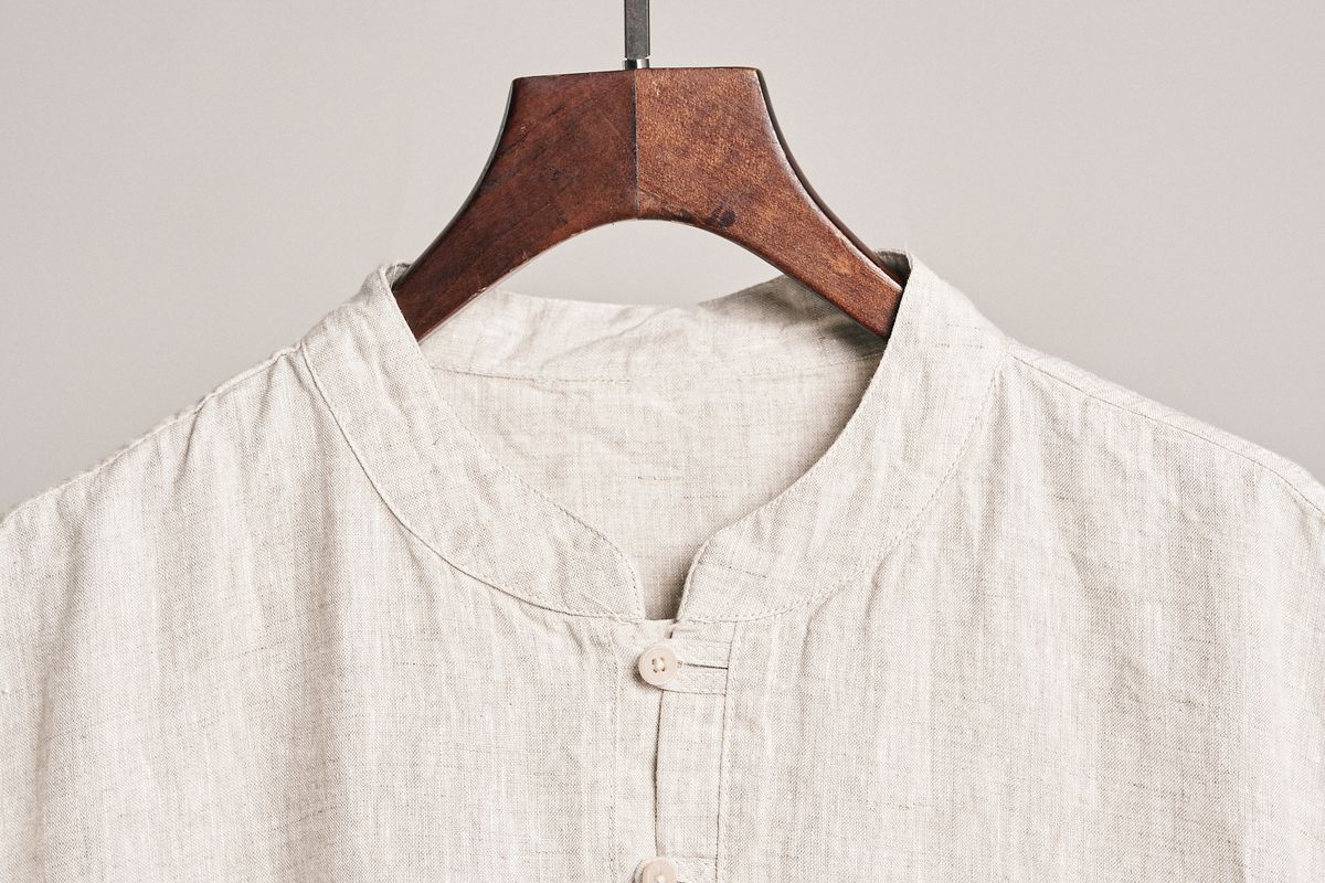 Crisp white linen shirt hanging on a wooden hanger