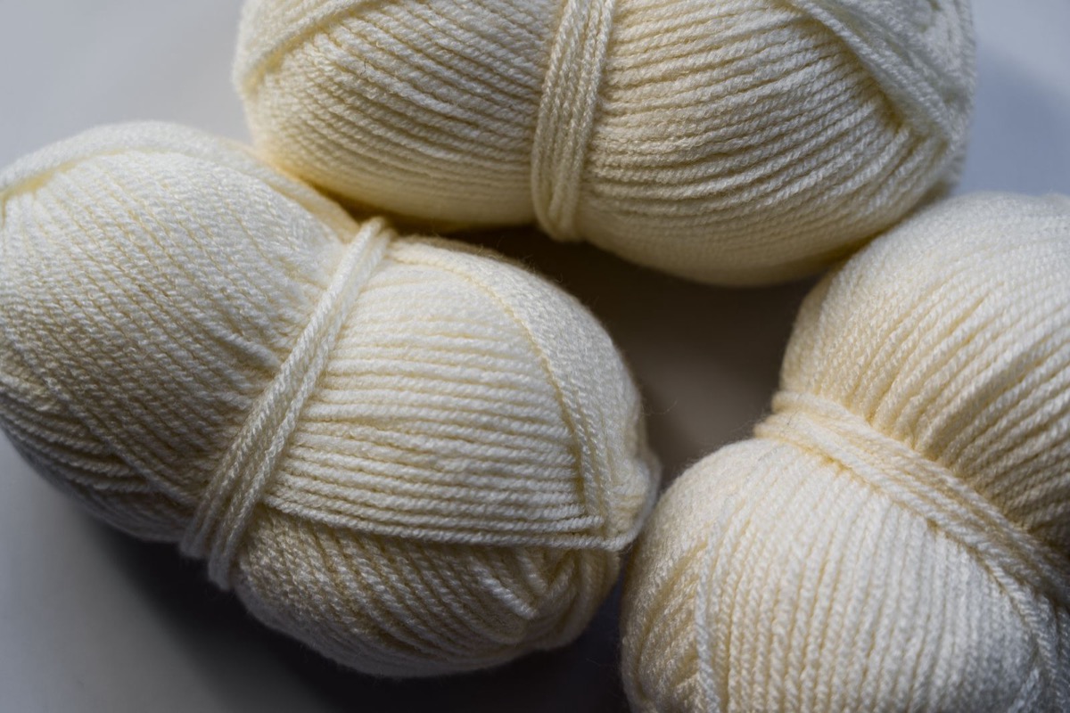 Close-up of cream wool yarn balls showing the ply and twist of the strands